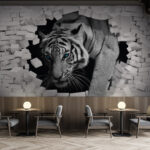 Papel de parede Tigre a romper um muro de tijolo branco.